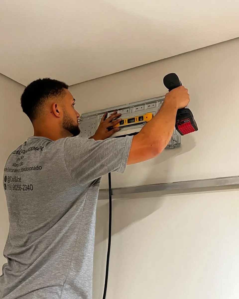 Técnico da Cold&Ice furando a parede com a furadeira para fixar o suporte de um ar condicionado